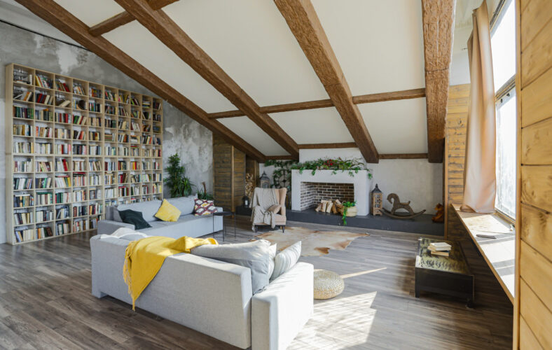 Dark loft style interior of big cozy country house. open plan apartment with kitchen area, rest zone and bed area. Huge windows and wooden decoration