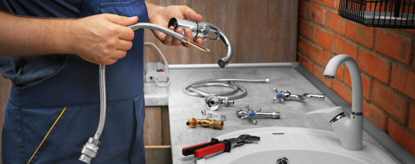 Plumber replacing faucet in kitchen, close up view